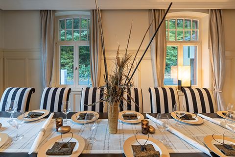 Salon mit gestreiften Stühlen und hohen Sprossenfenstern